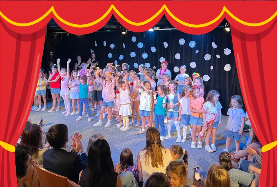 Grupo de niñas y niños saluda sobre el escenario al finalizar una presentación de baile