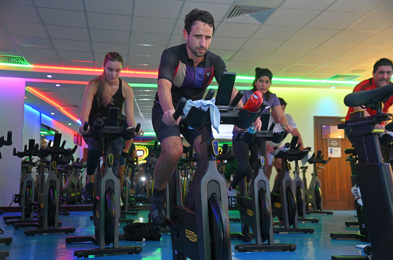 Participantes entrenando en bicicletas fijas durante una clase de Cycling