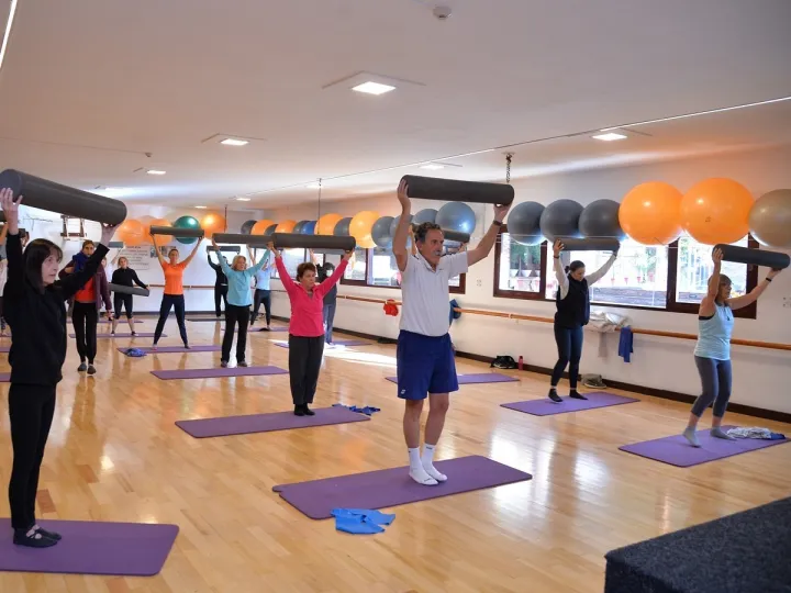 Clase grupal de Stretching con colchonetas y elementos de apoyo