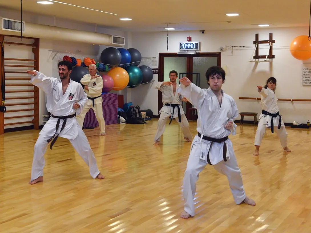 Grupo de adultos practicando una secuencia técnica de karate en el Club