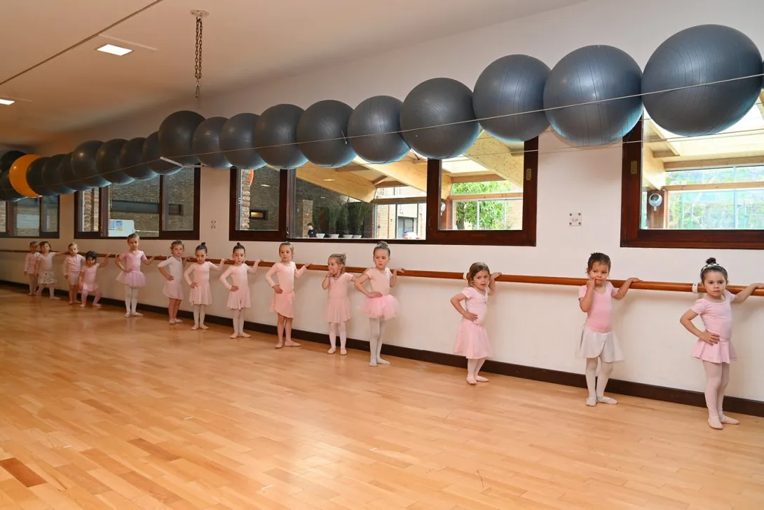 Niñas practicando ballet junto a la barra de la sala del Club