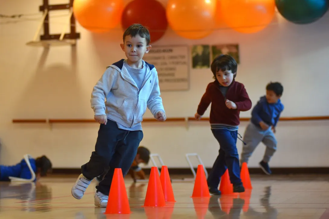 Niño recorriendo un circuito de conos durante una actividad de Educación Física Inicial