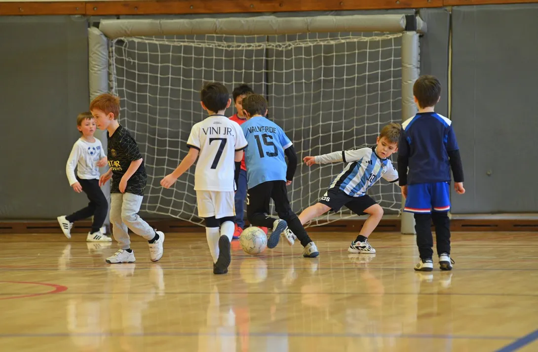 Niños jugando al fútbol sala en el gimnasio del Club