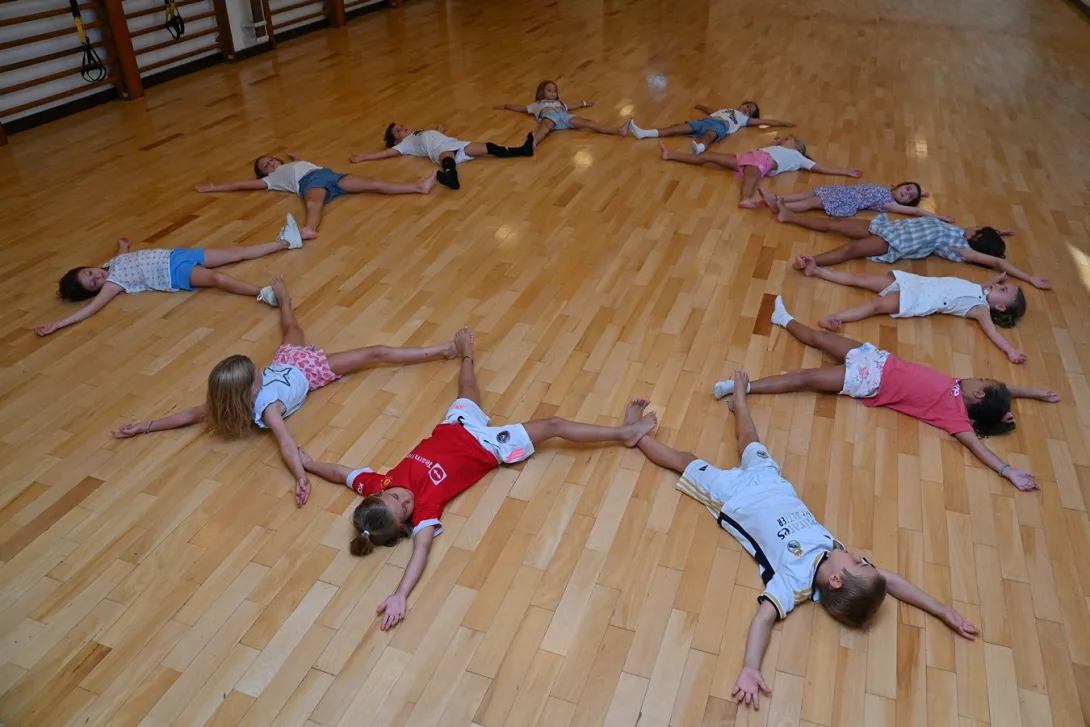 Niños realizando una actividad de relajación durante una clase de yoga